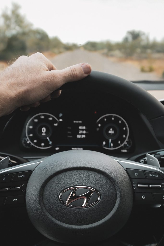 Picture of a steering wheel of a Hyundai looking out on a road