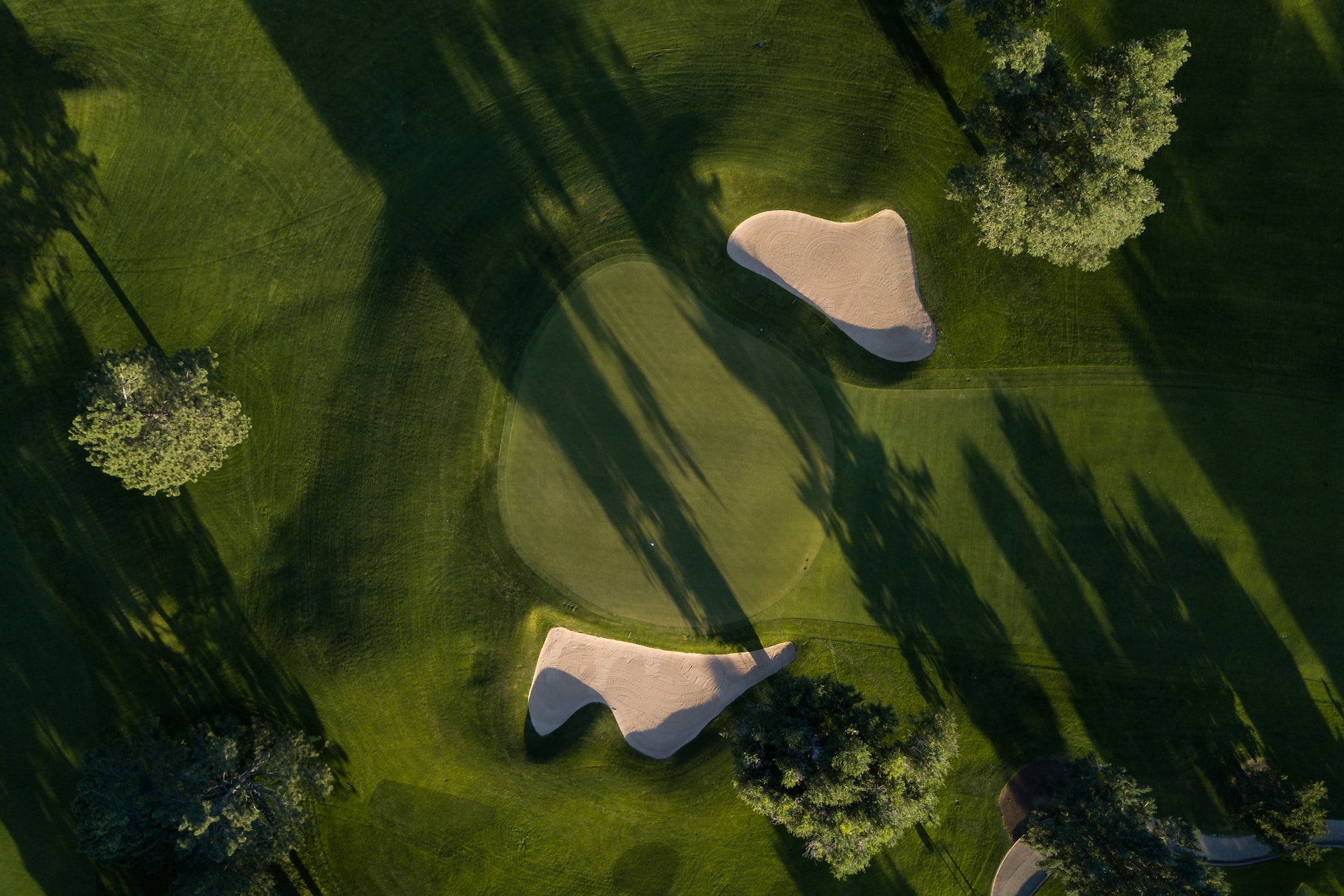 A Bird's eye view of the green of a golf course with bunkers on each side