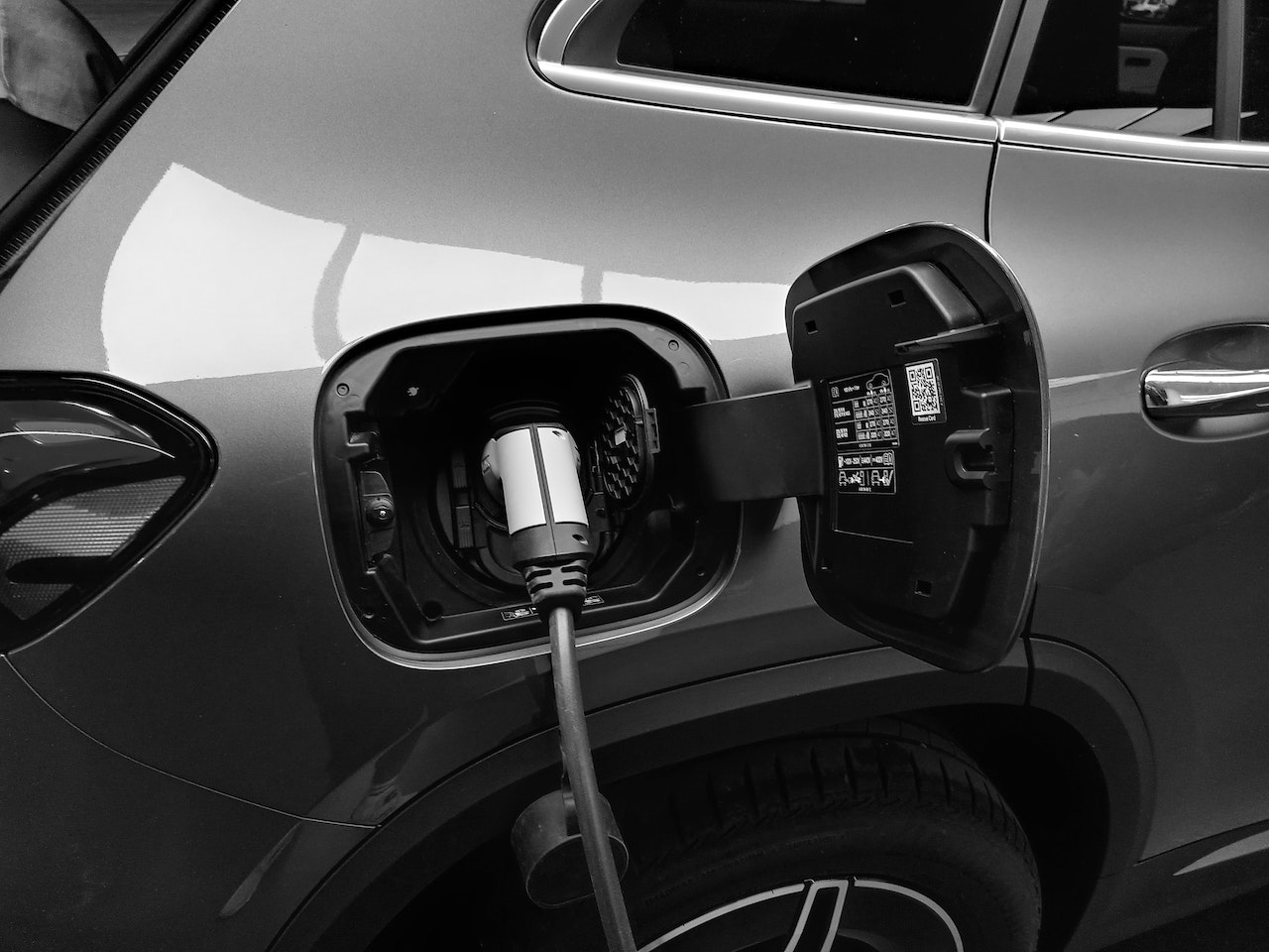 A grey electric car charging zoomed in on the charging port of the vehicle