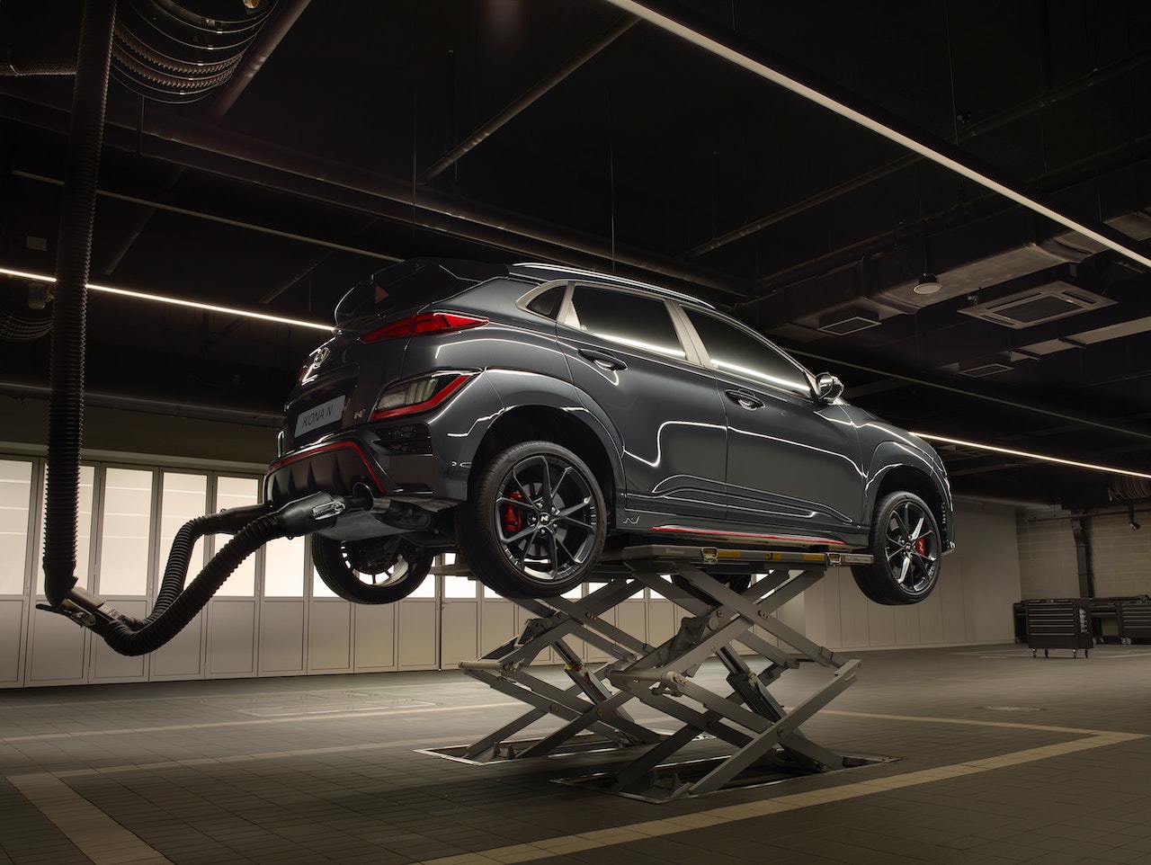 A Hyundai EV lifted up at the service shop to make sure the car is running properly