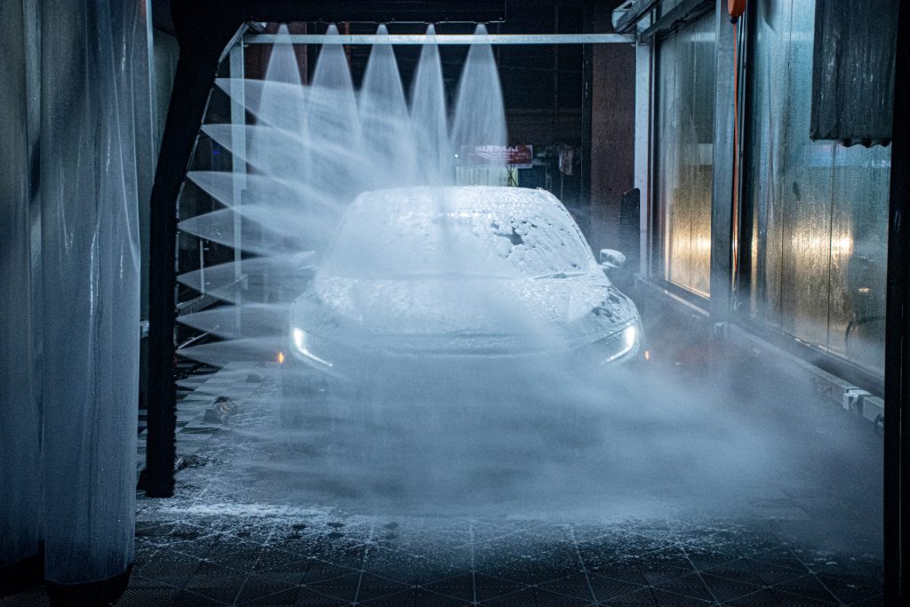 A car driving through a car wash with soap all over the car
