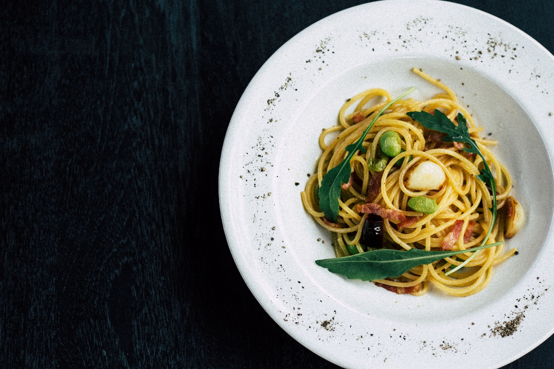 A bowl of pasta on a black background.