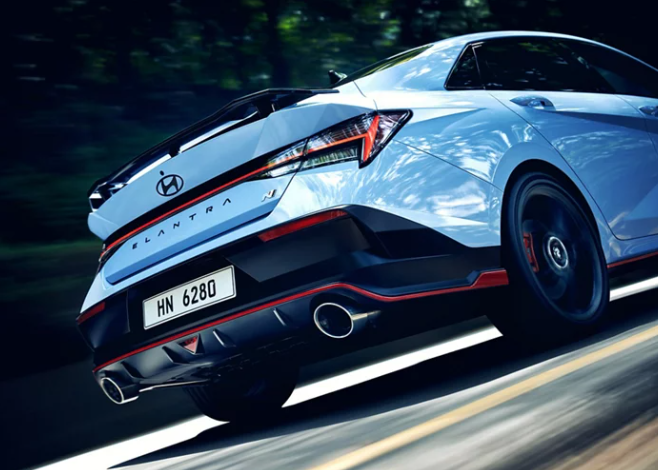 2024 Hyundai Elantra N sports sedan in blue paint driving fast on the highway outside of Dublin, California.