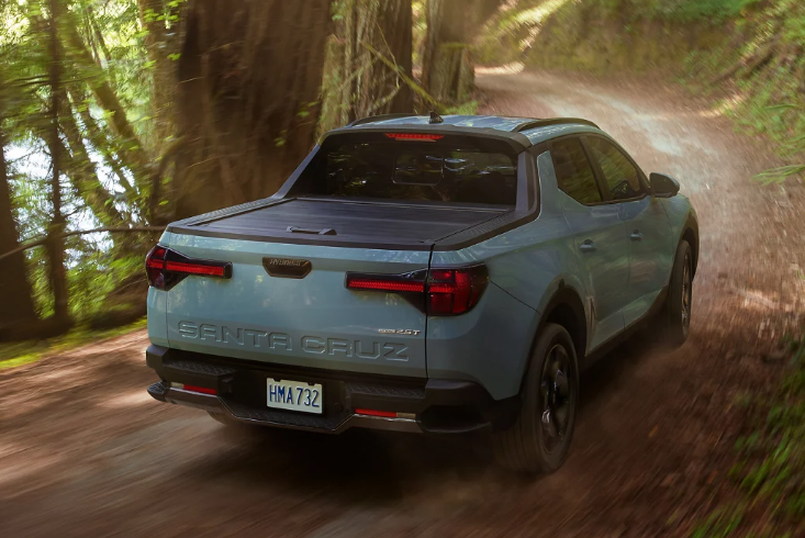 2024 Santa Cruz Hyundai in blue paint driving in a forested area outside of Dublin, California.