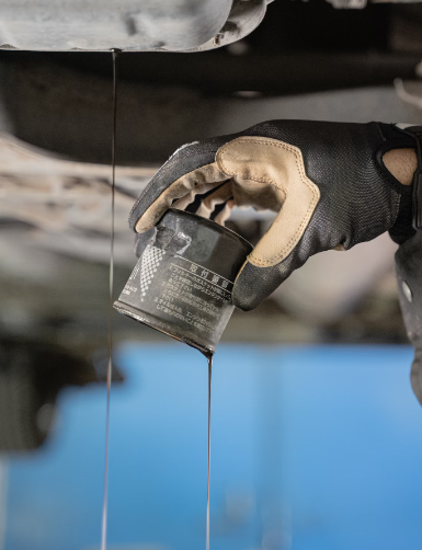 Automotive mechanic holding a dropping oil filter at a Dublin, CA Hyundai dealership.
