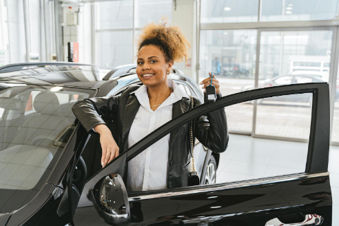 Woman holding up the keys to her new Hyundai vehicle.